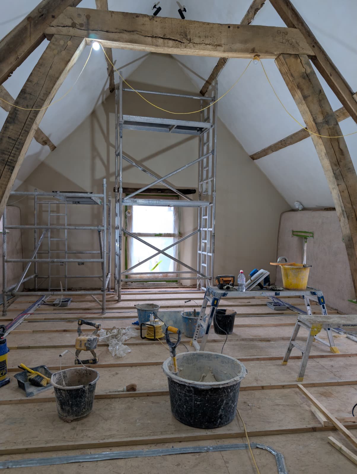 Access scaffold tower set up inside the roof space, finished hempcrete walls visible behind